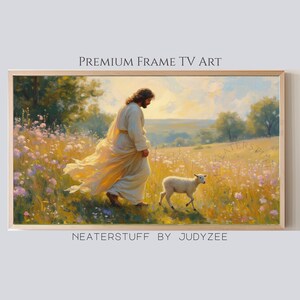 Könnte beinhalten: Gerahmtes Landschaftsgemälde, das eine Figur in fließenden Gewändern zeigt, die mit einem Lamm über ein Feld geht. Das Kunstwerk befindet sich in einem Holzrahmen und zeigt den Text "PREMIUM FRAME TV ART" und "NEATERSTUFF BY JUDYZEE". Die Farbpalette umfasst weiche Gelb-, Grün- und Blautöne.
