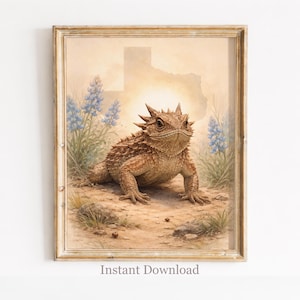 May include: Framed print featuring a detailed illustration of a Texas horned lizard in a desert landscape. The artwork includes bluebonnets, the Texas outline, and the text "Instant Download". The frame has a distressed, gold finish.