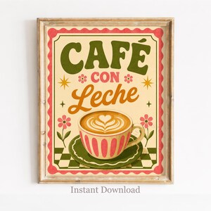 Op de afbeelding: Een ingelijste print met de woorden "CAFÉ CON LECHE" in groen en oranje. De afbeelding toont een koffiekopje met latte art, op een groene schotel. De achtergrond is beige met roze en groene decoratieve elementen.
