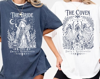May include: A dark blue t-shirt featuring a white graphic of a bride in a witch hat with the text 'THE BRIDE', '2026', and 'Emily's Bachelorette' and a white t-shirt featuring a graphic of three witches with the text 'THE COVEN', '2026', and 'Emily's Bachelorette'.
