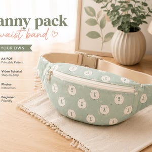 Peut inclure: Un sac banane vert clair avec un motif de têtes d'ours blanches, une fermeture éclair blanche et une sangle de taille beige réglable. L'image contient le texte : Fanny pack waist band, SEW YOUR OWN, A4 PDF Printable Pattern, Video Tutorial Step-by-Step, Photos Instruction, Beginner Friendly.