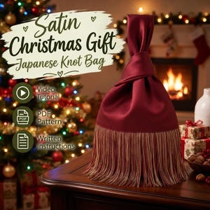 Può includere: Una borsa a nodo giapponese in raso bordeaux scuro con una lunga frangia multicolore alla base. La borsa presenta un design unico con manico annodato. Il testo sull'immagine recita: Satin Christmas Gift Japanese Knot Bag, Video Tutorial, PDF Pattern, Written Instructions.