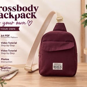 May include: A deep burgundy crossbody backpack with a wide beige adjustable strap and gold-tone hardware. A white rectangular patch on the front features the text: MADISON AVE. LINCOLN CENTER BROOKLYN FORT HAMILTON. The image includes text for a sewing pattern.