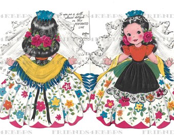 May include: A vintage paper doll of a girl wearing a white dress with colorful flowers, a yellow shawl, and a blue veil. The doll is cut out and ready to be assembled. The text on the card reads "To use as a doll please detach on this perforated line."