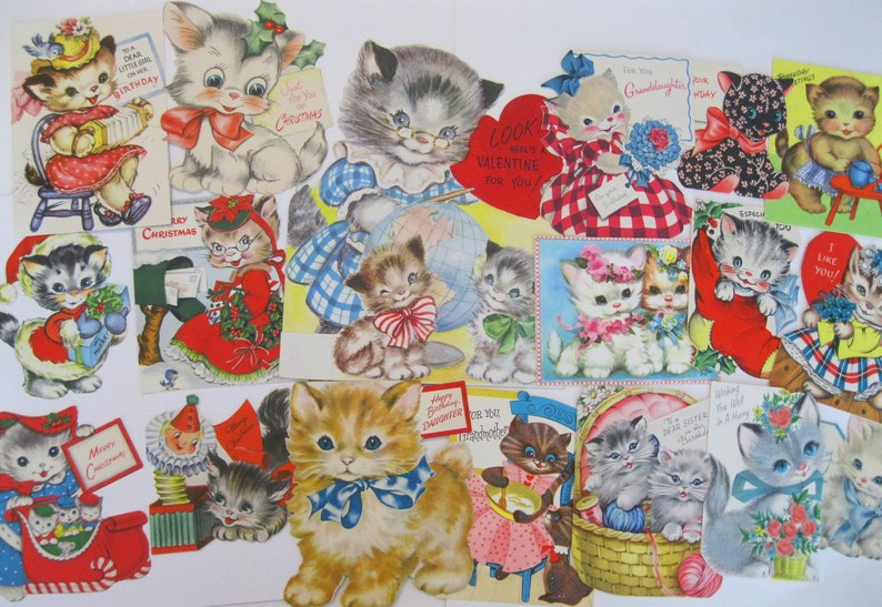 May include: A collection of vintage Valentine's Day and Christmas cards featuring kittens and cats. The cards are decorated with red, blue, and green colors and feature various festive themes, including "Look Here's a Valentine for You", "Merry Christmas", and "I Like You!"
