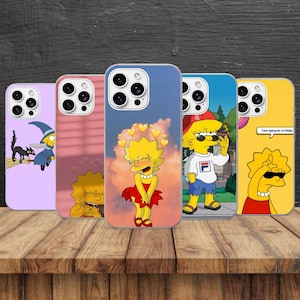 May include: Five smartphone cases featuring Lisa Simpson in various scenes. One is light purple with a witch, one is pink with a silhouette, one is blue with hearts, one shows Lisa in a red cap, and one is yellow with the text TEM SENHA OTÁRIO.