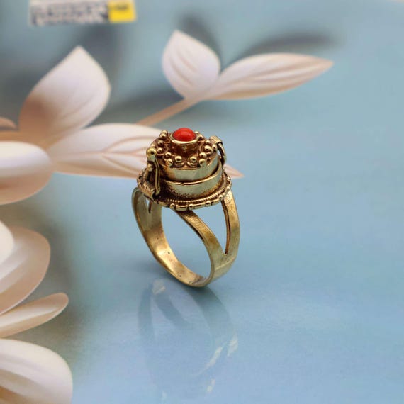 A handmade brass ring with a hidden hinged compartment — the poison ring is one of history's most dramatic jewelry concepts, and this one actually looks the part.