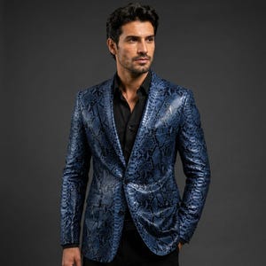 May include: A blazer featuring a blue and black snakeskin pattern with a notched lapel, two front flap pockets, and a single-button closure. The garment is worn over a solid black button-down shirt with a pointed collar and long sleeves.