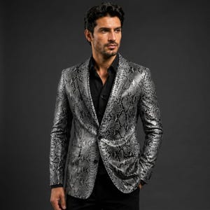 May include: A blazer featuring a grey and black snakeskin pattern with a notched lapel, two front flap pockets, and a single-button closure. The garment is worn over a solid black button-down shirt with a pointed collar and long sleeves.