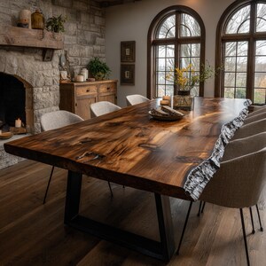Peut inclure: Une grande table à manger rectangulaire dotée d'un plateau en bois massif à bord naturel avec des grains et des nœuds visibles, reposant sur une base en métal noir en forme de U, entourée de plusieurs chaises rembourrées à pieds fins.