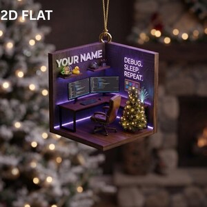 May include: A 2D flat hanging ornament depicting a miniature home office workspace with a desk, two computer monitors, a brown chair, a small Christmas tree, and shelves. The text reads YOUR NAME and DEBUG. SLEEP. REPEAT. in white and purple lettering.