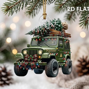 May include: A 2D flat Christmas tree ornament shaped like a green off-road vehicle. The vehicle carries a snow-dusted pine tree and skis on its roof, is decorated with colorful string lights, and features a plaid bow and the word Name on the side.