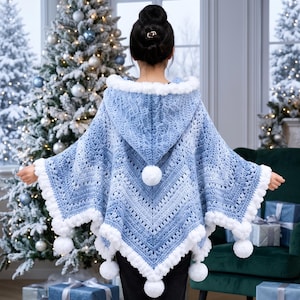 Op de afbeelding: Een lichtblauwe gehaakte poncho met capuchon, voorzien van een gestructureerd chevronpatroon, een witte pompon aan de punt van de capuchon en een witte pomponrand langs de gehele geschulpte zoom. Het kledingstuk is gemaakt van zacht verloopgaren.