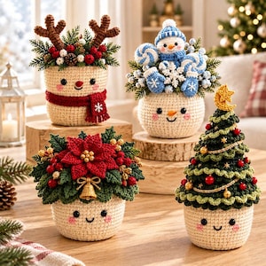 May include: Four crocheted festive decorations featuring cream-coloured bases with smiling faces. One has reindeer antlers and a red scarf, one has a blue snowman and candy canes, one has a red poinsettia and gold bell, and one has a green Christmas tree.