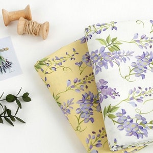 以下が含まれることがあります： 花柄の生地が2枚。1枚は黄色地に紫の花柄、もう1枚は白地に紫の花柄です。