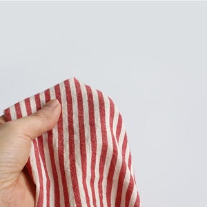 May include: A white ceramic mug with a black handle and the text "But First, Coffee" in a bold, black font. The mug is set against a blurred background, suggesting a cosy setting.