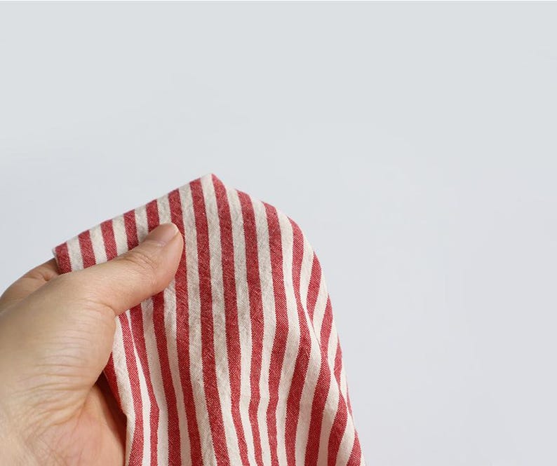 May include: A white ceramic mug with a black handle and the text "But First, Coffee" in a bold, black font. The mug is set against a blurred background, suggesting a cosy setting.