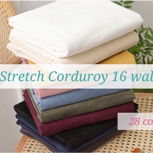 May include: A stack of fabric swatches in various colours, including white, beige, yellow, pink, blue, green, burgundy, black, and navy. The fabric is described as "Stretch Corduroy 16 wale" and is available in 28 colours.