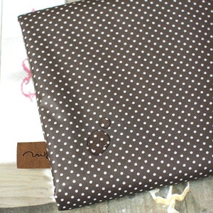 May include: A brown fabric with white polka dots. The fabric has a subtle sheen and is smooth to the touch.