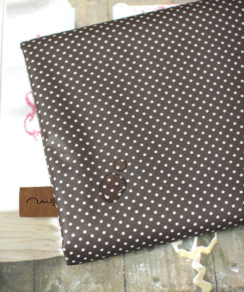 May include: A brown fabric with white polka dots. The fabric has a subtle sheen and is smooth to the touch.