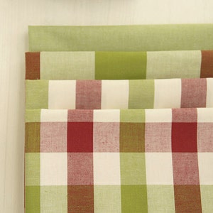 May include: Four folded fabric pieces in shades of green, red, and white. The top piece is a solid light green. The second piece has a brown and green block pattern. The bottom two pieces have a red, green, and white checkered pattern.