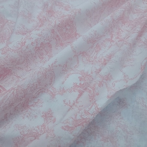 May include: White fabric with a pink floral pattern. The fabric has a subtle sheen and a soft texture.