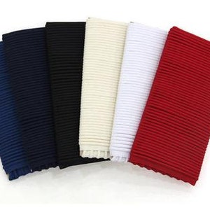 May include: Five ribbed fabric swatches in different colours: navy blue, black, cream, white and red.