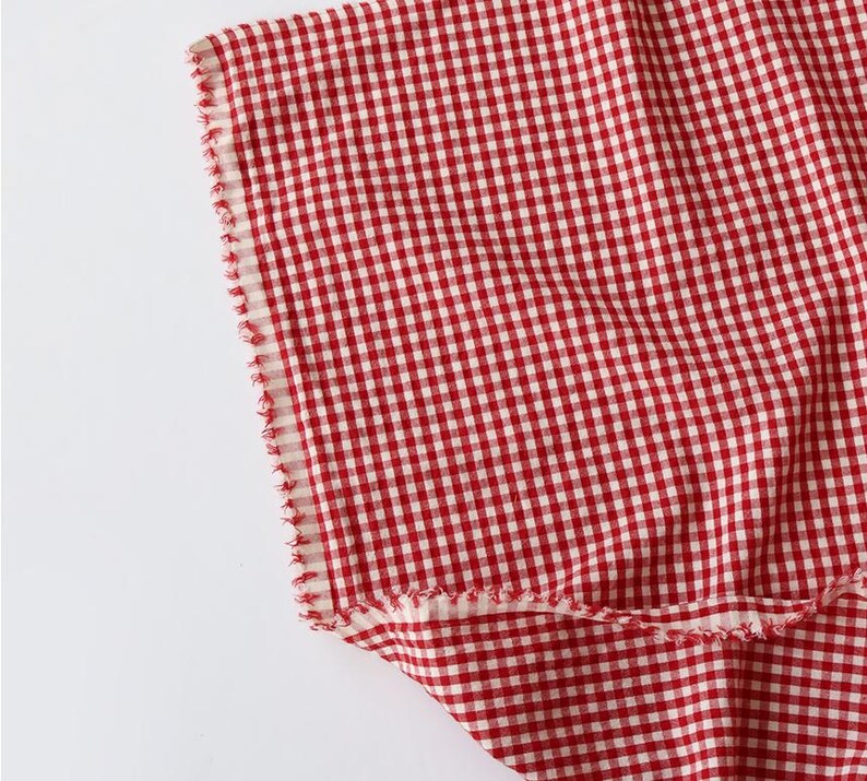 May include: A white ceramic mug with a black handle and the text "But First, Coffee" in a black, handwritten-style font. The mug is on a white surface.