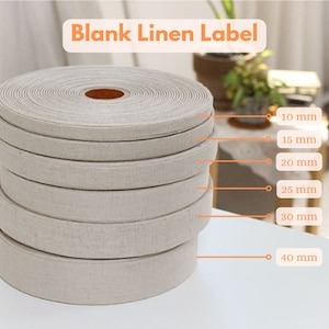 Puede incluir: Un conjunto de seis etiquetas de lino beige de diferentes anchos, que van de 10 mm a 40 mm. Las etiquetas están enrolladas y apiladas unas sobre otras. El texto "Blank Linen Label" está escrito en naranja en la parte superior de la imagen. Las etiquetas se miden en milímetros y pulgadas.