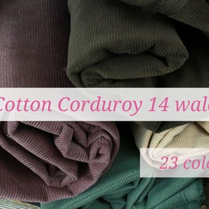 May include: Close-up of rolls of cotton corduroy fabric in various colours, including brown, green, pink, and beige. The fabric is 14 wale and is available in 23 colours.