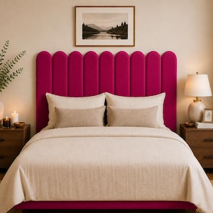 May include: A magenta velvet headboard with a vertical scalloped design, paired with a beige bedspread, two large square pillows, and two rectangular lumbar pillows. The headboard features a series of rounded, upright panels in a vibrant pink.