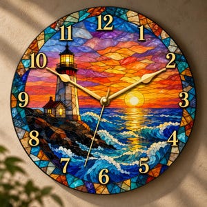 May include: A round wall clock featuring a stained glass style design of a lighthouse on a rocky shore at sunset. The clock face displays gold numerals from 1 to 12 and gold hands against a vibrant background of orange, blue, and purple.