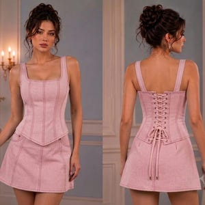 Front and back views of a model wearing a pink denim-style corset top and matching mini skirt with white contrast topstitching.