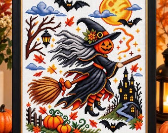 May include: A framed cross-stitch embroidery featuring a pumpkin-headed witch flying on a broomstick. The scene includes a yellow moon, black bats, a dark castle, autumn leaves, and orange pumpkins, all set against a white fabric background.