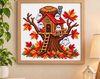 May include: A framed cross-stitch embroidery featuring a brown treehouse built into a tree trunk, surrounded by vibrant orange and red autumn leaves. Four small white ghosts with smiling faces are positioned around the house and tree.