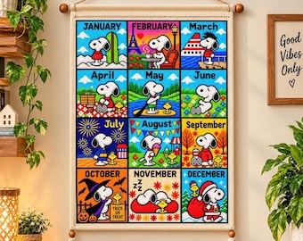May include: A wall hanging featuring a cross-stitch style calendar with twelve squares, each depicting Snoopy in seasonal scenes for every month of the year. The design includes text labels for January through December, with colourful illustrations of the character.