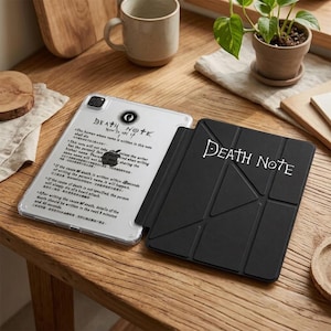 May include: A clear tablet case featuring the Death Note rules printed in black text and a black folding tablet cover with the Death Note logo in white. The clear case displays the rules in English and Chinese, while the black cover has a geometric design.