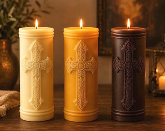 May include: Three cylindrical pillar candles in cream, golden yellow, and dark brown, each featuring a raised, ornate cross design on the front. Each candle is lit with a single flame at the top, casting a warm glow on the wax surfaces.