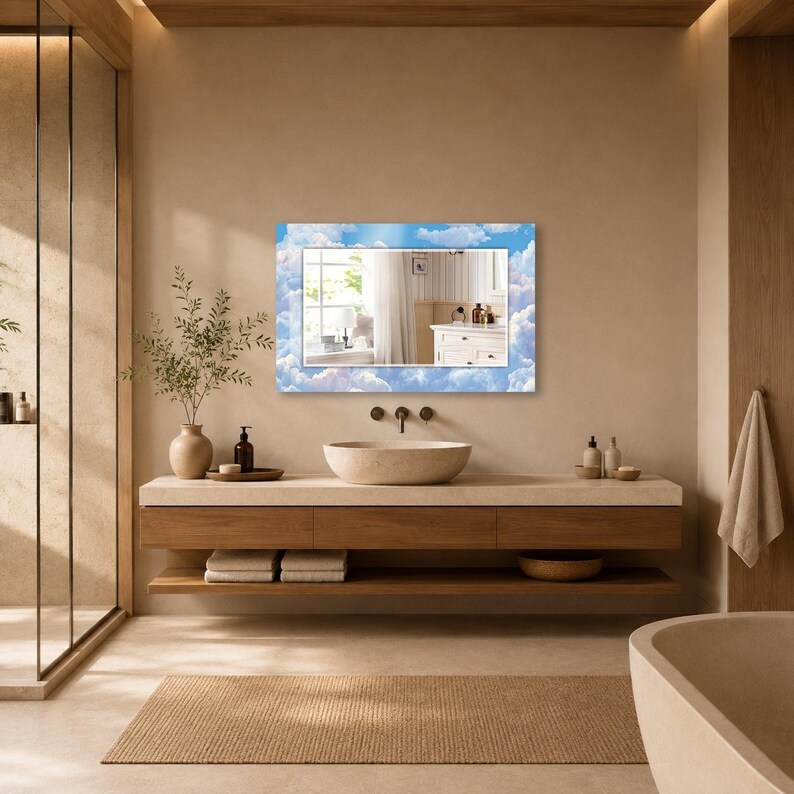 May include: A rectangular wall mirror featuring a decorative border printed with a blue sky and white clouds pattern. The central reflective glass surface provides a clear view of an interior space, including a window and white cabinetry.