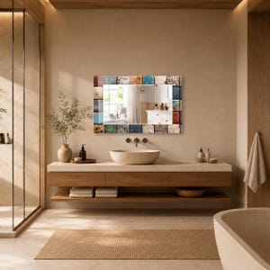 May include: A rectangular wall mirror featuring a decorative frame composed of small, multi-colored square tiles in shades of blue, brown, orange, and cream. The mirror has a reflective glass center that displays a view of a bathroom interior.