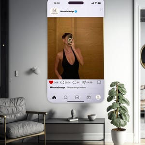 Peut inclure: Un miroir mural rectangulaire conçu pour ressembler à une interface de publication sur les réseaux sociaux. Le miroir affiche un cadre numérique avec des icônes de likes, commentaires et partages, incluant le texte MirroriaDesign.