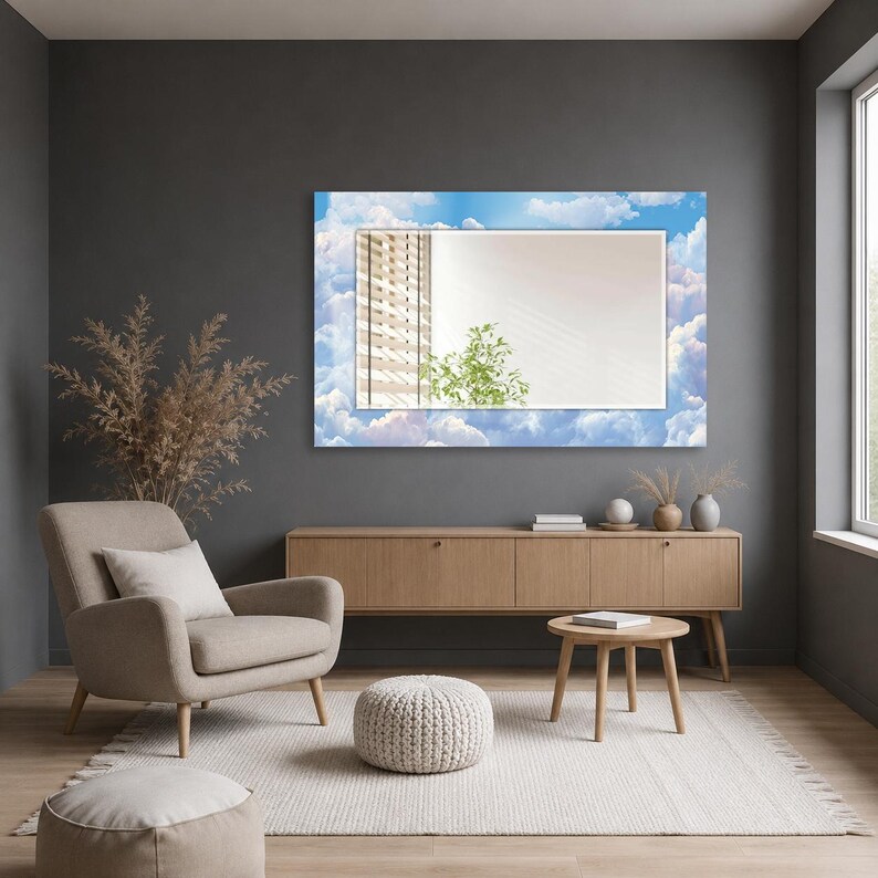 May include: A rectangular wall mirror featuring a decorative border printed with a bright blue sky and white clouds. The central reflective glass surface shows a reflection of a window with blinds and a green plant, framed by the sky-themed border.
