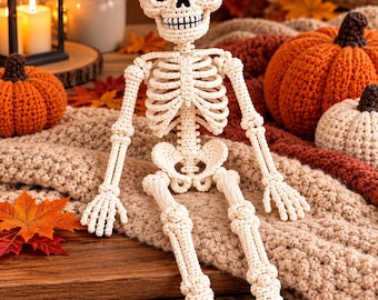 May include: A crocheted skeleton figure made of off-white yarn with black yarn detailing for the eye sockets and mouth. The figure features a detailed rib cage, articulated limbs, and a rounded skull, crafted with visible stitches throughout the body.