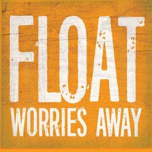 May include: A square, orange wooden sign with the words "FLOAT WORRIES AWAY" in large, distressed white letters. The background has a wood grain texture, giving it a rustic appearance.
