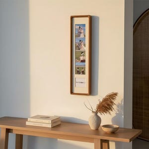 May include: A vertical wooden picture frame with a light-coloured mat board containing four rectangular photo slots and one square slot at the bottom. The square slot features the text "MEMORIES" in a simple, dark, sans-serif typeface.