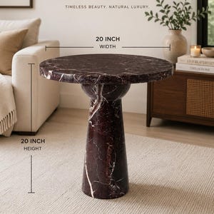 May include: A round side table crafted from dark burgundy marble with white veining, featuring a pedestal base. The table has a 20 inch width and a 20 inch height. Text on the image reads MARBLE ELEGANCE, TIMELESS BEAUTY, NATURAL LUXURY.