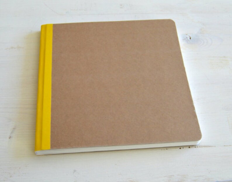 Puede incluir: Un cuaderno marr&oacute;n con una franja amarilla en el lomo.