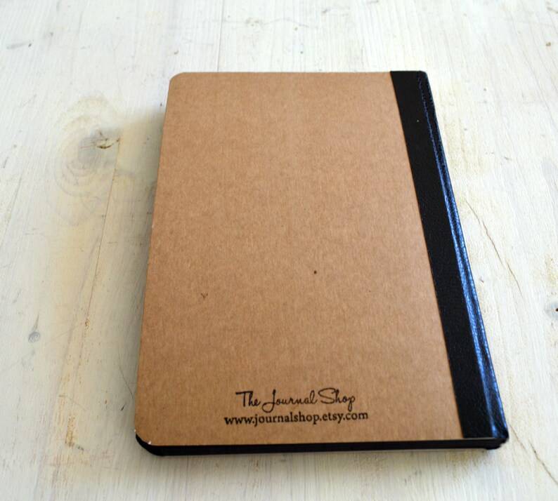 Pode incluir: A capa de tr&aacute;s de um di&aacute;rio marrom com uma lombada preta e o texto "The Journal Shop www.journalshop.etsy.com" impresso nela.