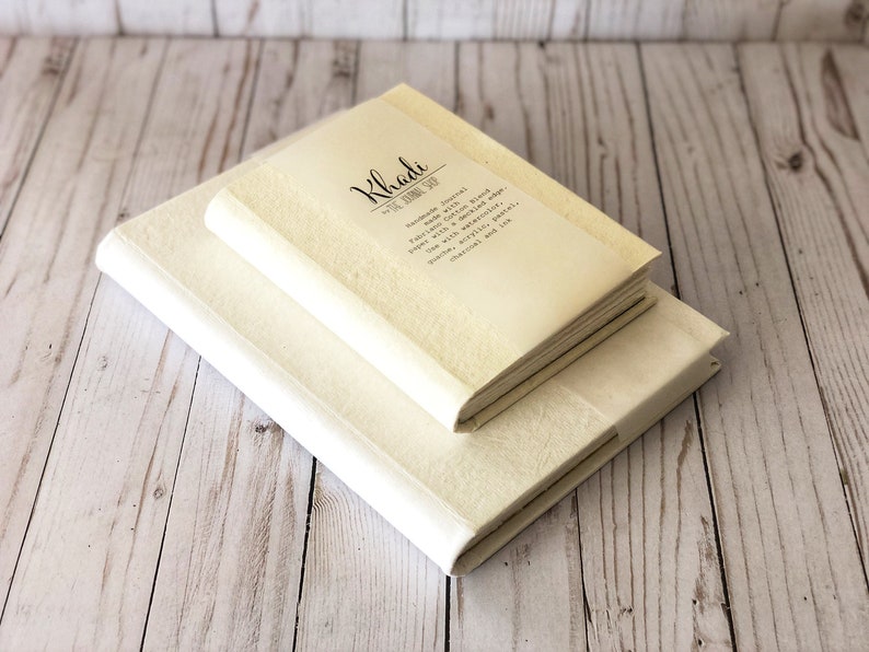 May include: Two white Khadi journals with hand-made journal paper with cotton blend, bound with a buckling edge. Use with recycled paper, pencils, pens, acrylic and ink.  Natural and chemical free.