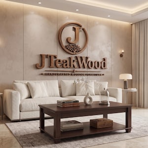 May include: A dark brown wooden coffee table with a lower shelf, featuring a stack of books and a small wooden box on the bottom, and a white vase with flowers on top. The wall behind displays a large wooden JTeakWood logo and text.